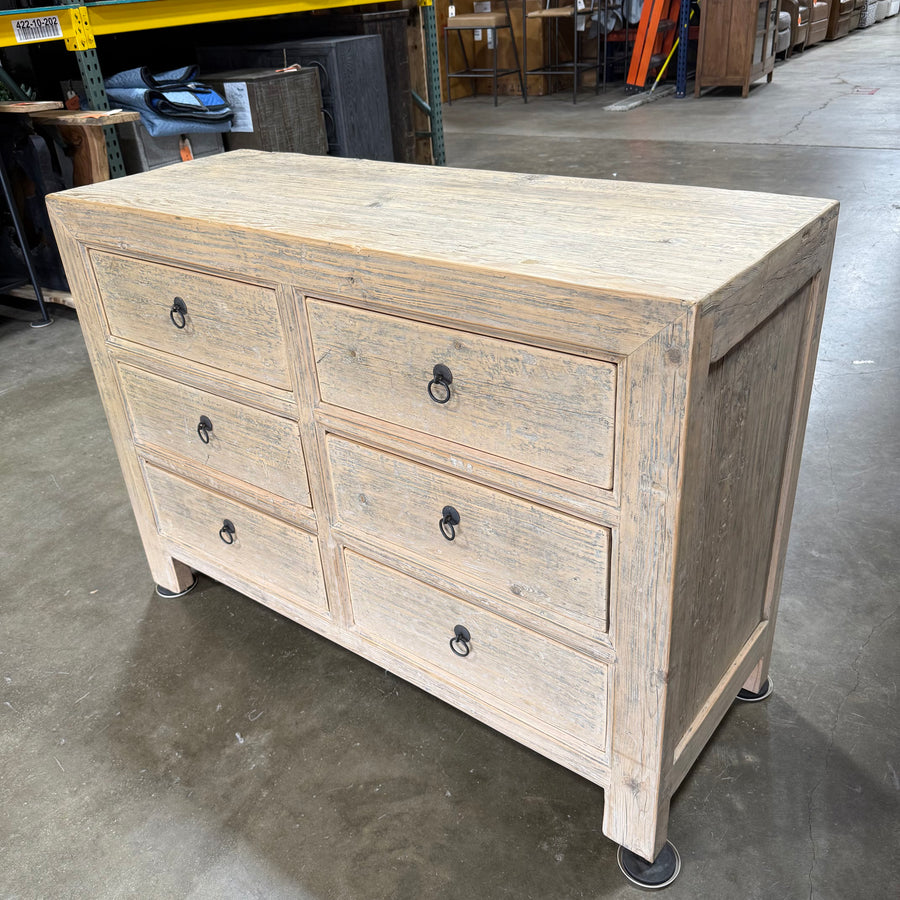 Wooden dresser with six drawers in a warehouse setting